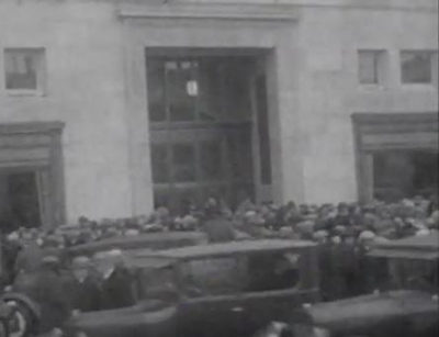 a large crowd of people gather in front of the Hudson's Bay Store